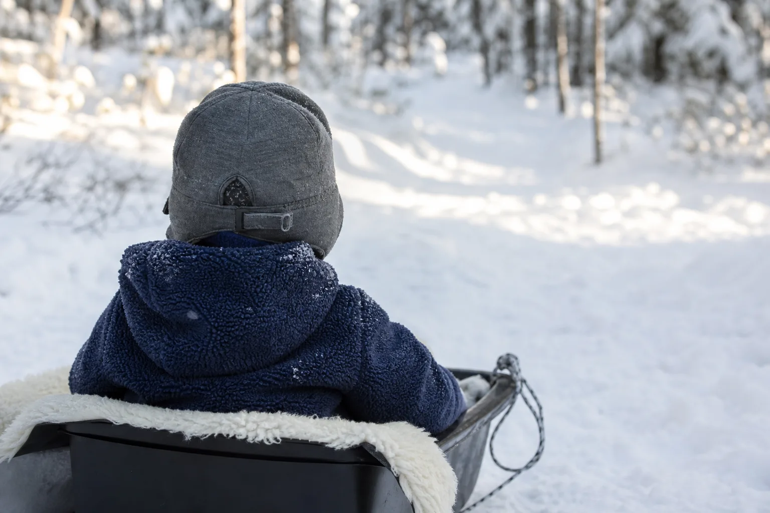 Mössa med öronlappar och hakband bakifrån